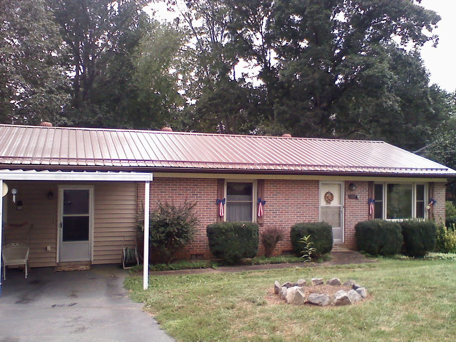Bronze metal roof and carport on a brick ranch home — Roof Repair work by our crew in Bertram
