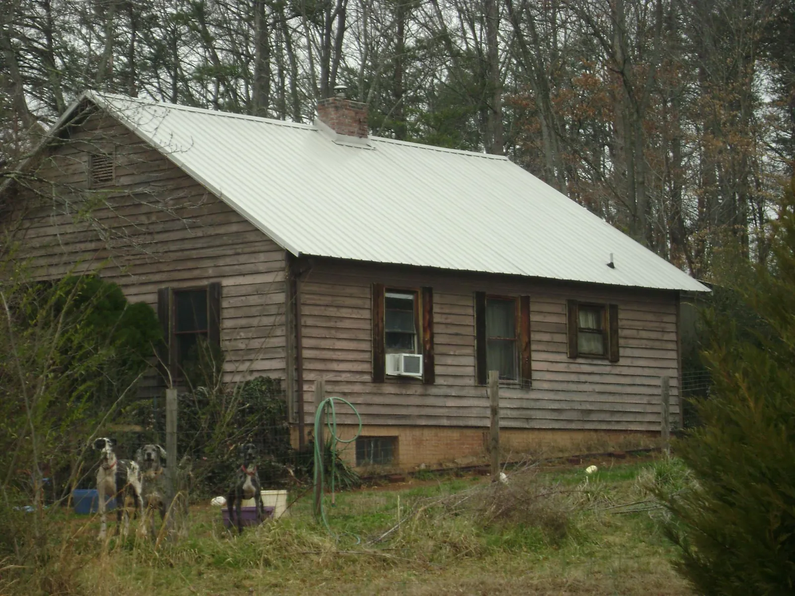 White metal roof on an old wood sided farmhouse, from a Metal Roof Installation job in Bertram